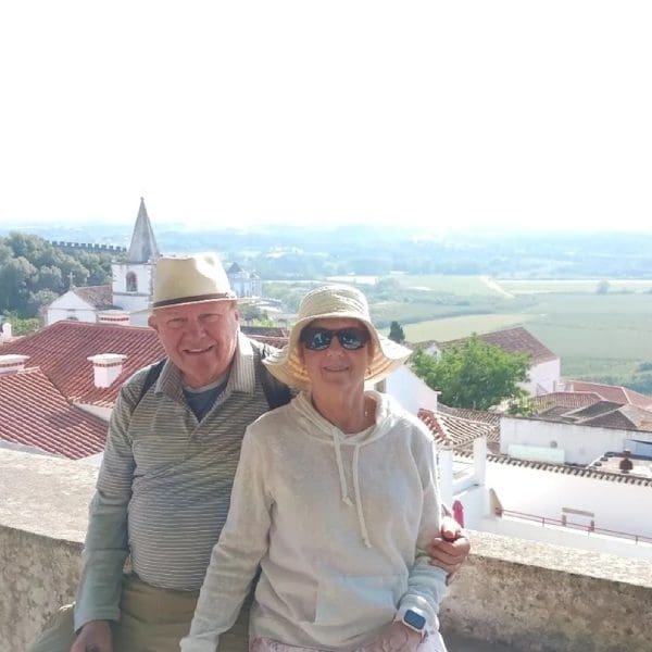 Two older people standing on a wall near the town.