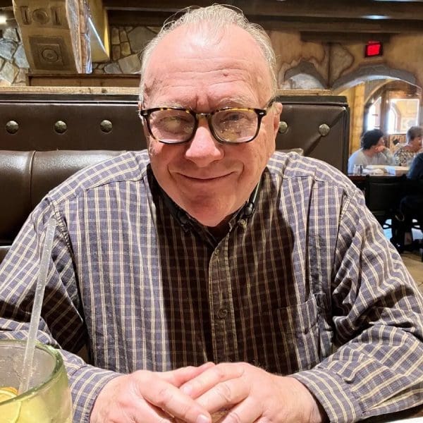 A man sitting at a table with glasses on.